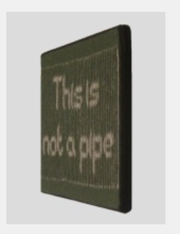 An illusion viewed from the right, with a black background and white text reading "This is not a pipe".